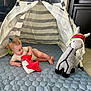 baby, child, indoor, play, toy, plush_llama, striped_teepee, mat, floor, clothing, hat, curious, crawling, infant, soft_toy, childhood, cute, relaxed, home, playtime