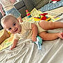 baby, child, toy, crawling, smiling, indoor, blanket, playmat, sofa, denim_shorts, person, floor, happy, cute, home, toddler, legs, hand, play, living_room