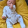 Dax is registered to the contest to win money with this photo: baby, infant, onesie, bear_pattern, blanket, yellow_blanket, hand, face, footed_pajamas, cute, child, newborn, soft, cozy, lying_down, indoors, sleepwear, expressive_face, small_hand, portrait