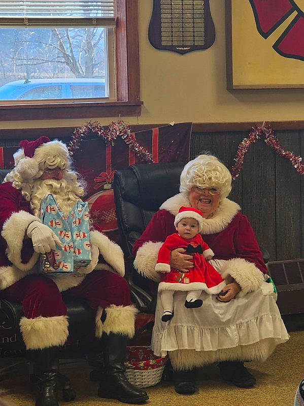 Karissa is registered to the contest to win money with this photo: child, christmas, christmas_decoration, christmas_eve, christmas_ornament, event, fictional_character, fur, hat, headwear, holiday, joy, lap, living_room, person, red, room, santa_claus, smile, toddler