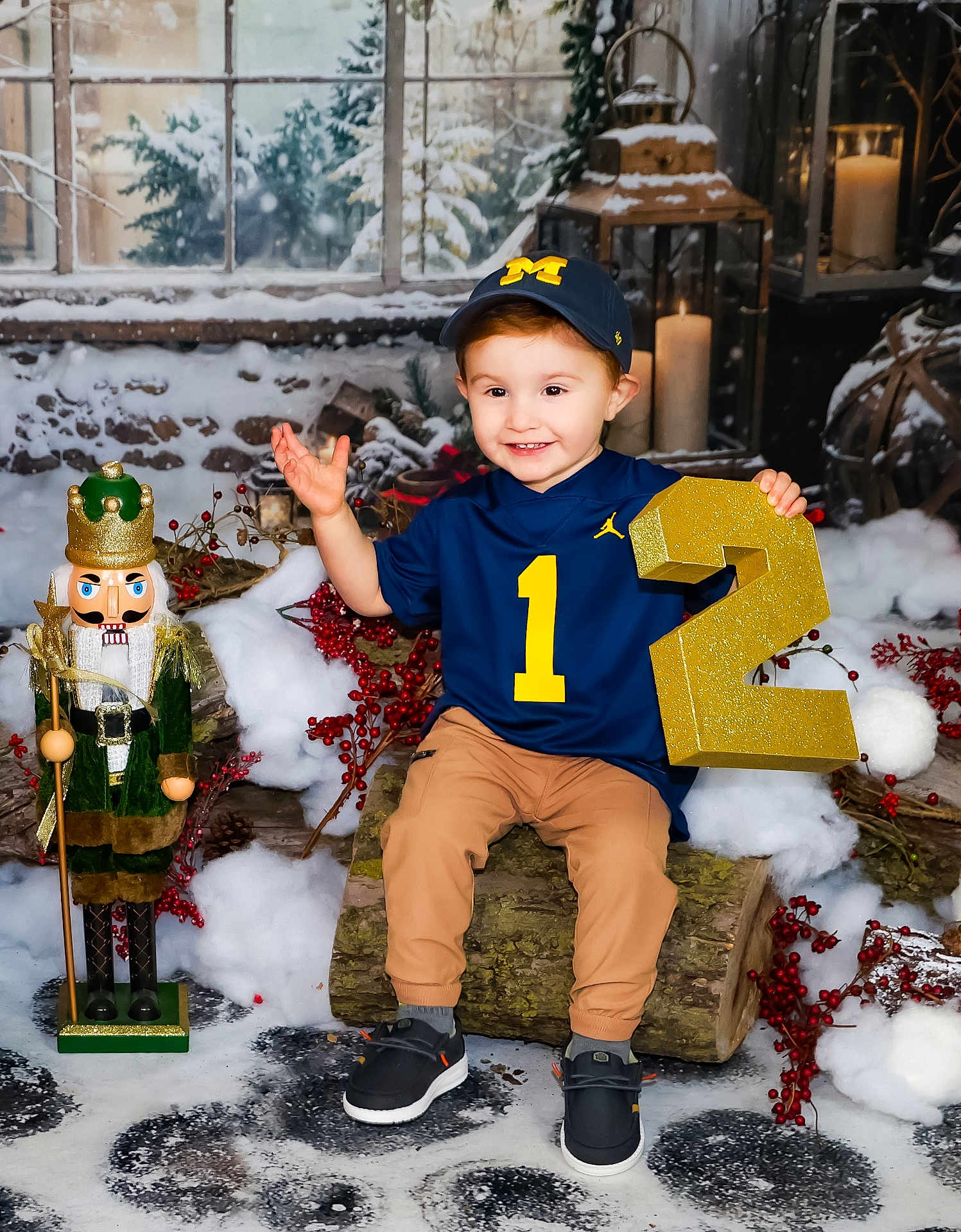 Xanderlee is registered to the contest to win money with this photo: child, toddler, smiling, blue_jersey, baseball_cap, number_two, log_seat, nutcracker, winter_scene, snow, red_berries, candles, lantern, indoor, holiday_decor, brown_pants, black_shoes, festive, portrait, cute