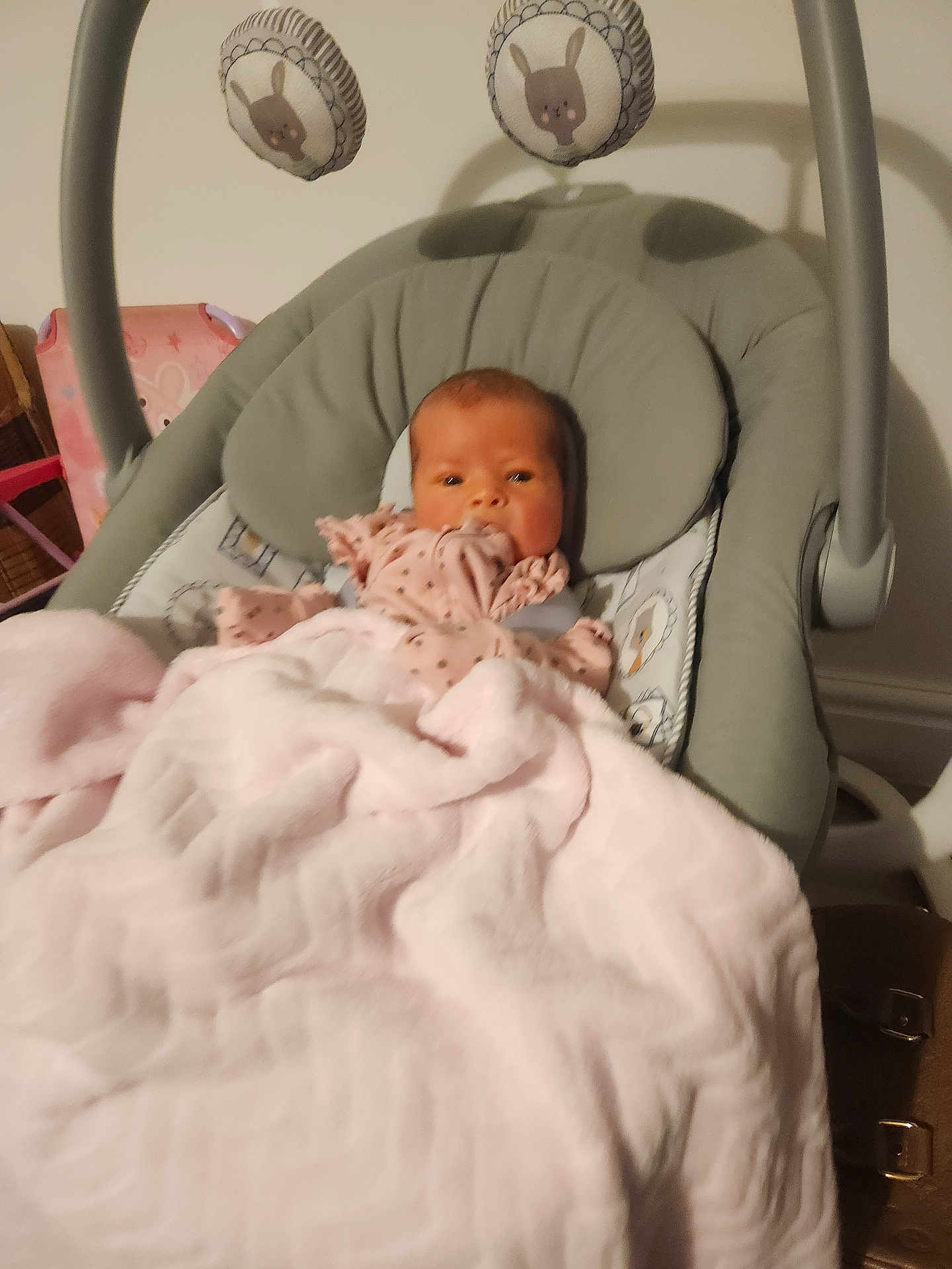 Layla-Rae is registered to the contest to win money with this photo: baby, blanket, baby_rocker, plush_toys, bunny, pink, gray, infant, child, face, soft, cushion, nursery, indoor, person, cute, sleeping_area, clothing, toy, comfort