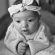 Elyana participe au concours pour gagner de l'argent avec cette photo : baby, infant, headband, knitted_sweater, blanket, close_up, black_and_white, portrait, cute, child, soft_texture, hands, expression, indoors, young, face, head, wide_eyes, cozy, resting