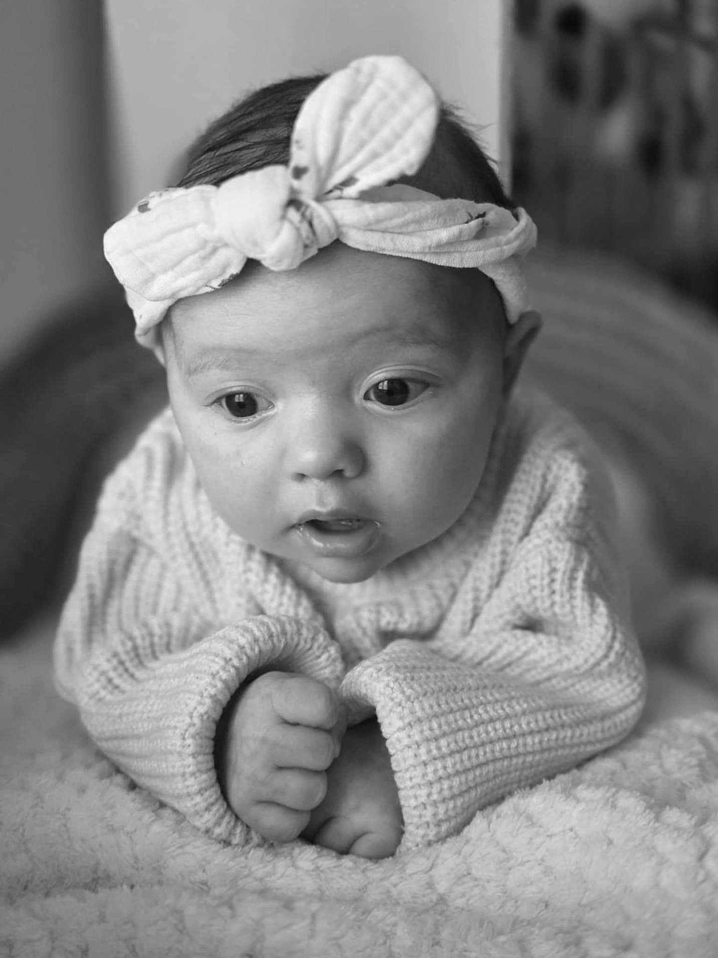 Elyana participe au concours pour gagner de l'argent avec cette photo : baby, infant, headband, knitted_sweater, blanket, close_up, black_and_white, portrait, cute, child, soft_texture, hands, expression, indoors, young, face, head, wide_eyes, cozy, resting