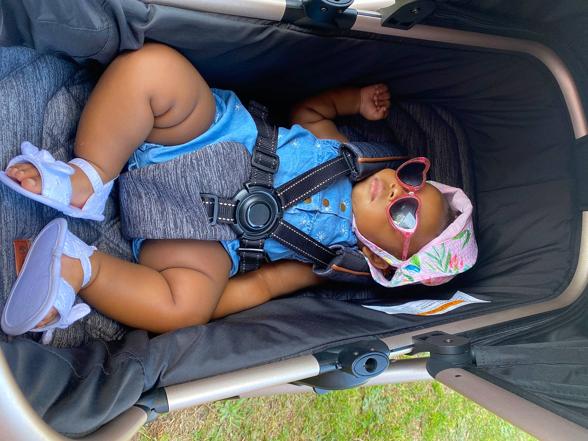Lailah is registered to the contest to win money with this photo: auto_part, automotive_design, automotive_exterior, bag, car_seat, comfort, eyewear, grass, hat, headwear, human_leg, knee, lap, leg, leisure, person, recreation, shorts, sitting, sunglasses