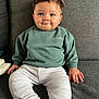 Sacha a rejoint le concours — aidez-le/la à gagner de superbes lots ! baby, child, smiling, sitting, indoor, couch, clothing, sweatshirt, pants, face, hands, feet, furniture, portrait, cute, happy, young_child, casual, relaxed, home