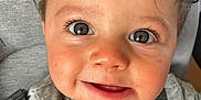 Sacha participe au concours pour gagner de l'argent avec cette photo : toddler, child, face, eyes, hair, smile, clothing, grey, red, levis, car_seat, seatbelt, closeup, curly_hair, expression, young_child, indoors, person, portrait, baby