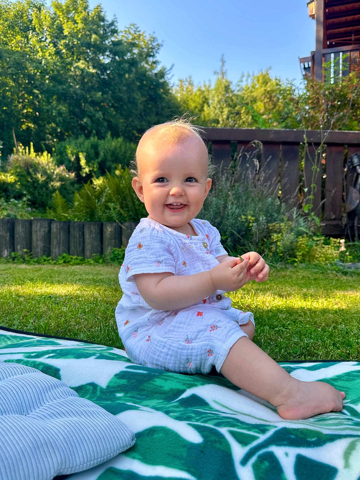 Mila Bella participe au concours pour gagner de l'argent avec cette photo : baby, child, smiling, outdoor, grass, blanket, greenery, sunlight, garden, fence, cute, happy, sitting, nature, infant, summer, daylight, clothing, portrait, playful