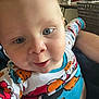 Bodie is registered to the contest to win money with this photo: baby, child, pajamas, close_up, indoor, face, blue_eyes, smile, sesame_street, colorful_clothing, person, cute, infant, skin, head, expression, young_child, portrait, human, sitting