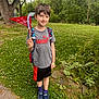 Odin joined the competition — help win amazing prizes! child, boy, outdoor, grass, tree, backpack, pennant, smile, shorts, tshirt, sneakers, nature, first_grade, flag, plant, daylight, happy, casual_clothing, sidewalk, summer