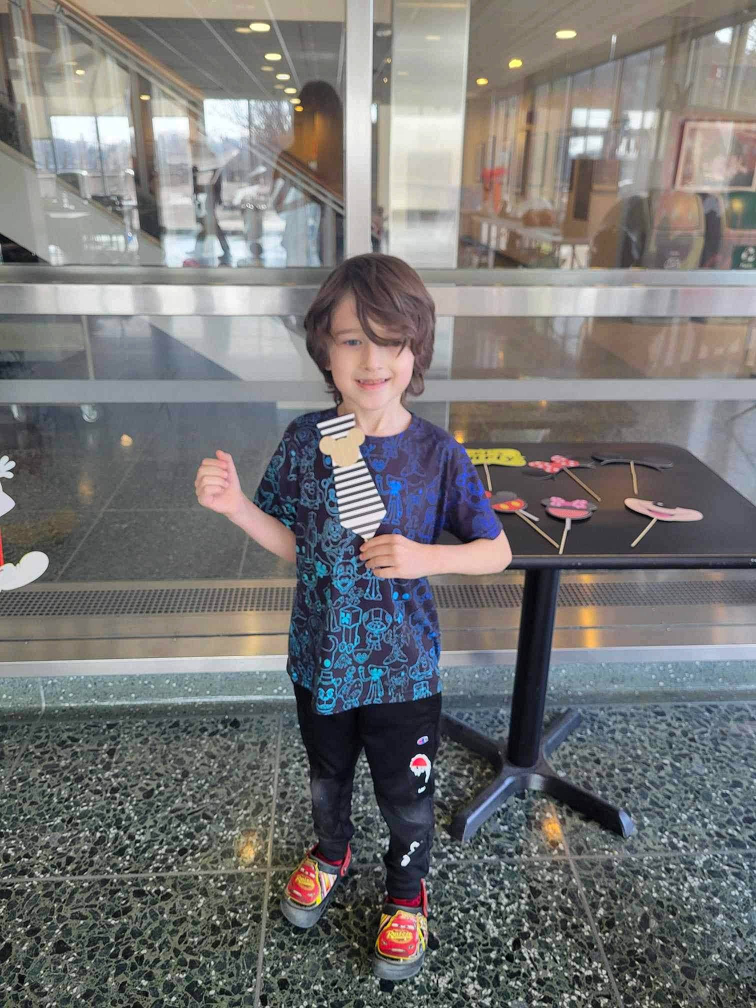 Odin is registered to the contest to win money with this photo: asphalt, child, city, electric_blue, flooring, fun, glass, human_leg, joy, leisure, metal, pedestrian, person, recreation, sandal, shadow, sitting, street, toddler, tourism