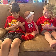 Lyla joined the competition — help win amazing prizes! baby, brothers_sisters, child, couch, curly_hair, cute, family, garfield, happy, headband, home, indoor, kids, playing, red_shirt, shorts, sitting, smiling, socks, toddler
