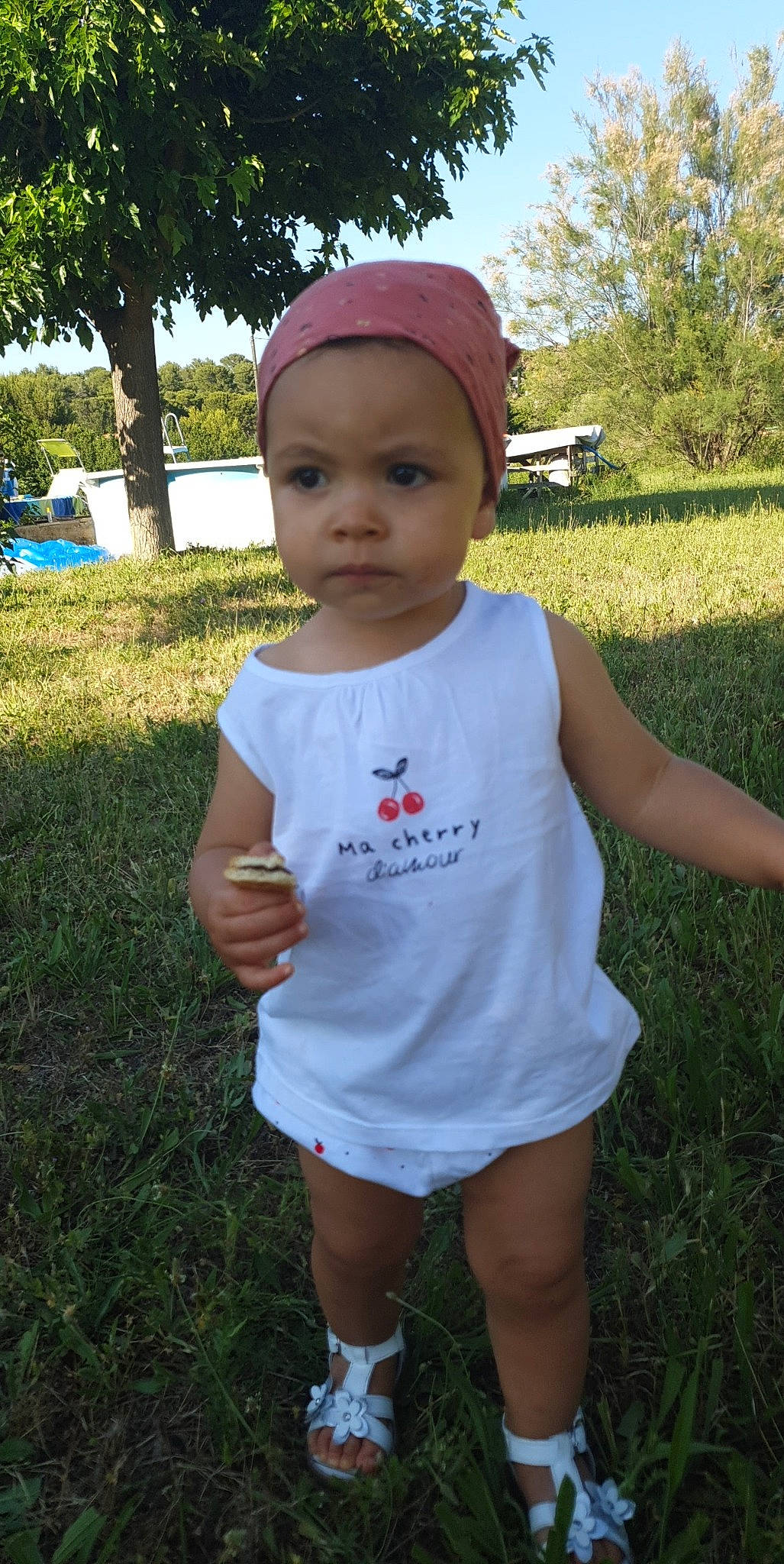 Ilyana a rejoint le concours — aidez-le/la à gagner de superbes lots ! active_tank, baby, baby_toddler_clothing, bonnet, cap, child, day_dress, headband, headwear, meadow, person, shade, summer, toddler