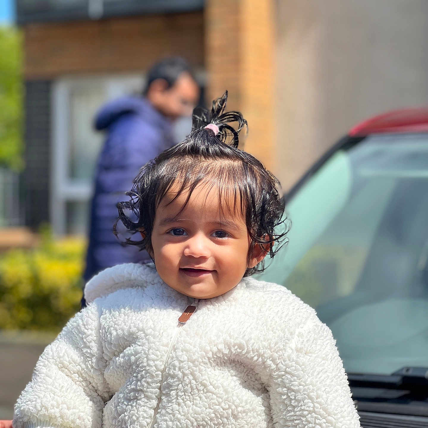 Thrishika is registered to the contest to win money with this photo: adult, background, blurred, car, child, curly_hair, cute, daylight, face, fashion, hair_tie, happy, outdoor, person, portrait, smiling, toddler, vehicle, warm_clothing, white_jacket