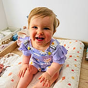 Freya participe au concours pour gagner de l'argent avec cette photo : baby, blue_eyes, child, clean_background, cushion, cute, daisy_pattern, face, feet, hands, happy, indoor, infant, natural_light, person, purple_clothing, sitting, smiling, toddler, wooden_floor
