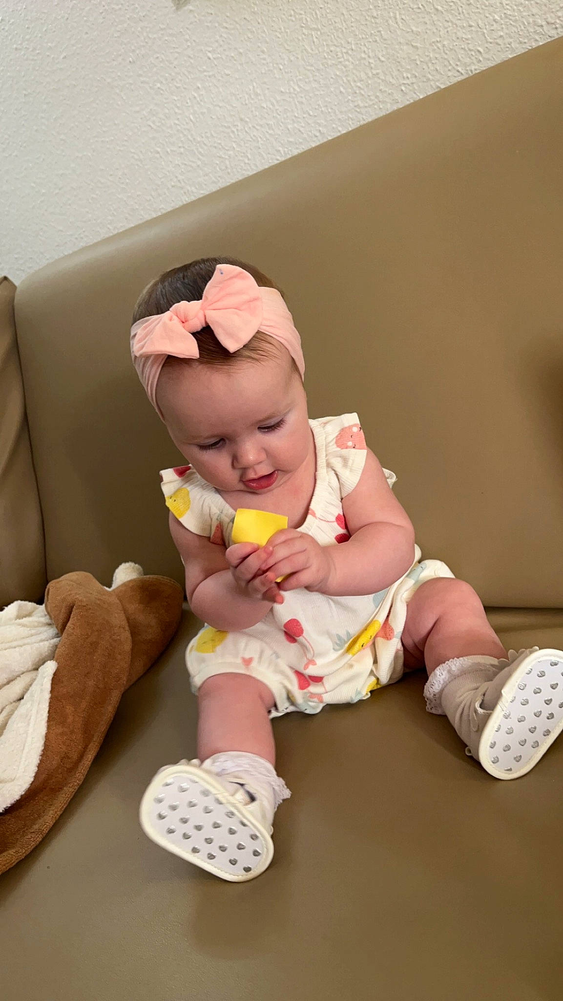 Esmé is registered to the contest to win money with this photo: baby, baby_toddler_clothing, child, comfort, finger, flooring, foot, human_leg, knee, pattern, person, pink, product, room, shoe, sitting, sleeve, sneakers, sock, thigh