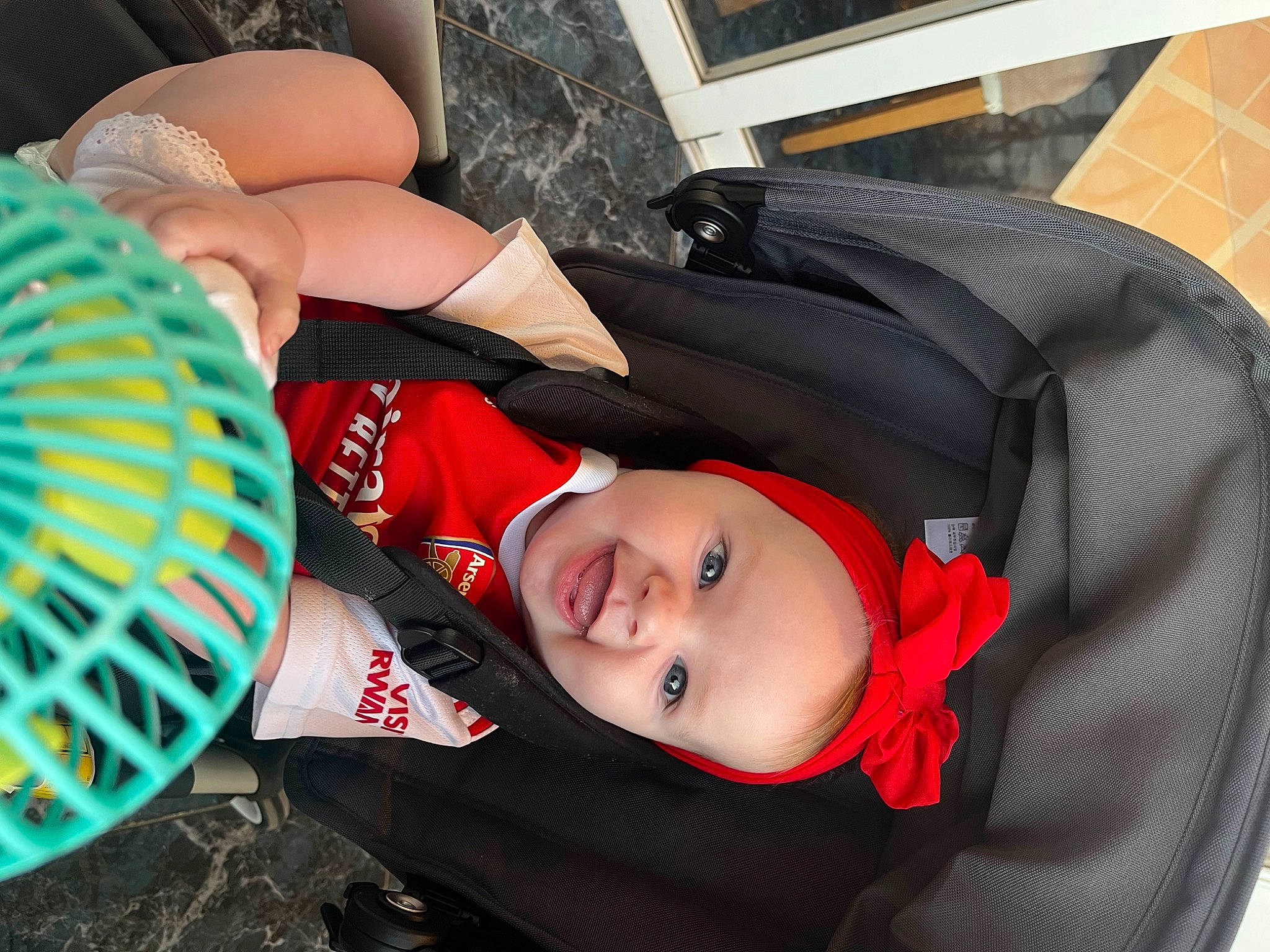 Esmé is registered to the contest to win money with this photo: audio_equipment, auto_part, automotive_wheel_system, baby, baby_carriage, baby_products, car_seat, carmine, child, comfort, fashion_accessory, fun, headgear, human_leg, mechanical_fan, person, sitting, smile, thigh, toddler