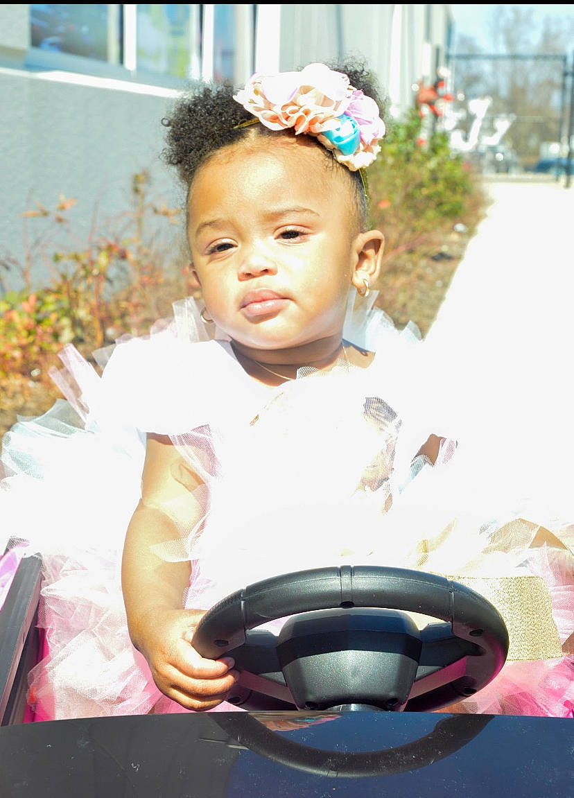 Syriah joined the competition — help win amazing prizes! baby, baby_products, baby_toddler_clothing, child, event, eyelash, fashion_accessory, flash_photography, fun, grass, happy, hat, headband, headpiece, iris, jewellery, person, pink, plant, sitting