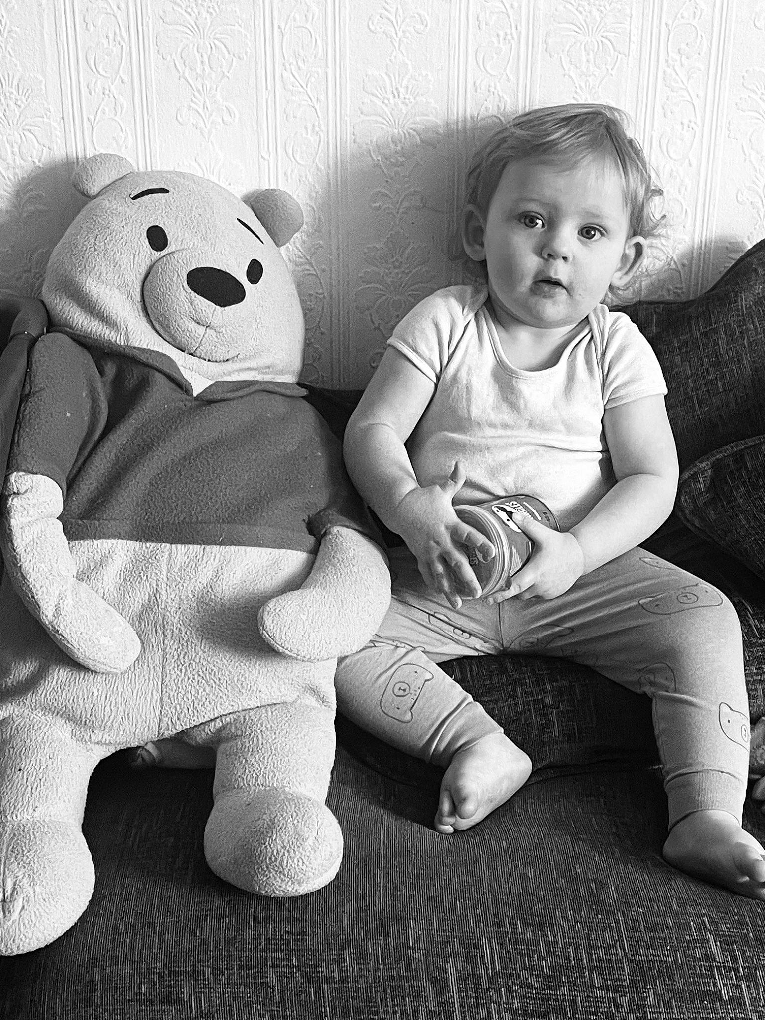 Alistair is registered to the contest to win money with this photo: black_and_white, comfort, flash_photography, fun, gesture, happy, head, human_body, knee, monochrome, monochrome_photography, nose, person, smile, stuffed_toy, style, surprise, t_shirt, teddy_bear, toddler