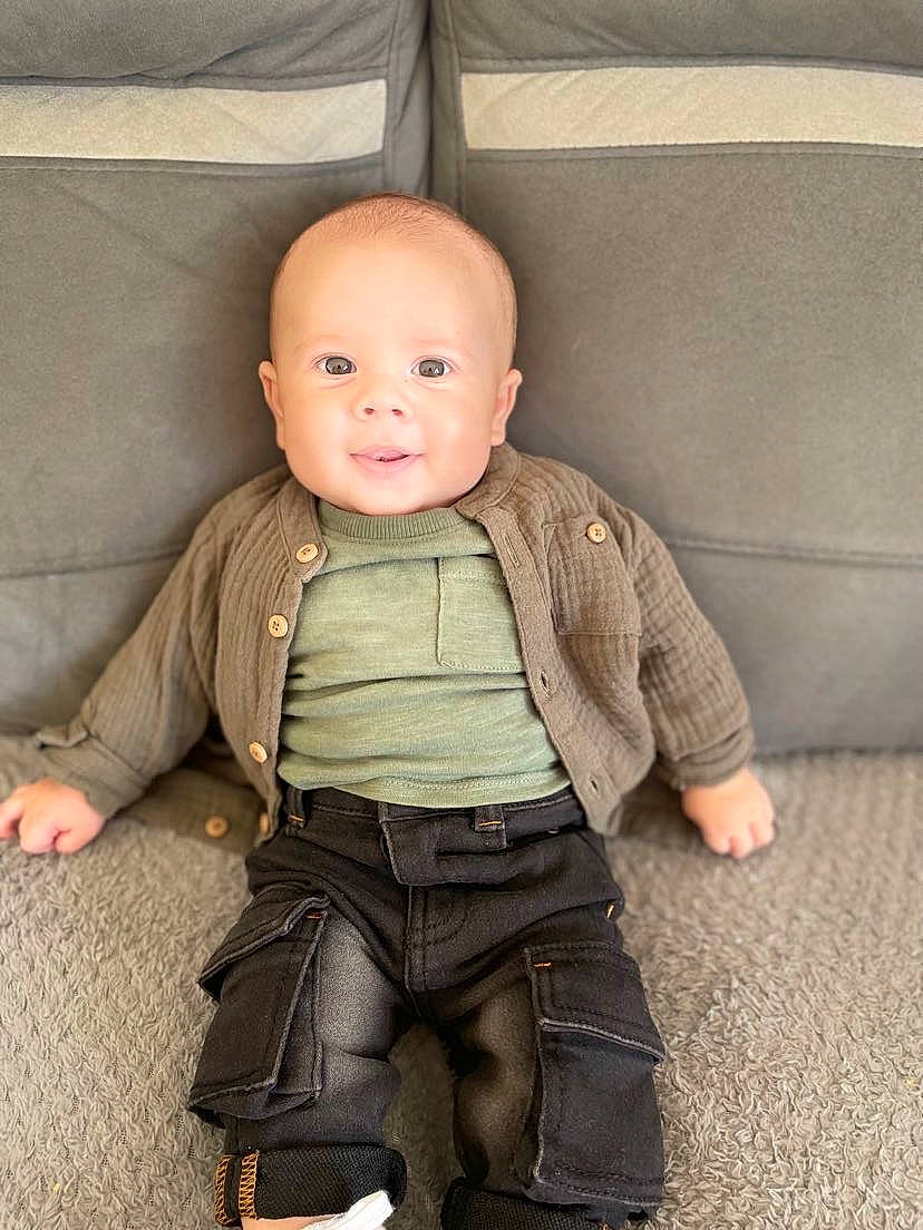 Maëlo participe au concours pour gagner de l'argent avec cette photo : baby, baby_toddler_clothing, chair, cheek, child, collar, dress_shirt, eye, finger, flooring, head, human_body, jacket, leg, outerwear, person, skin, sleeve, smile, standing