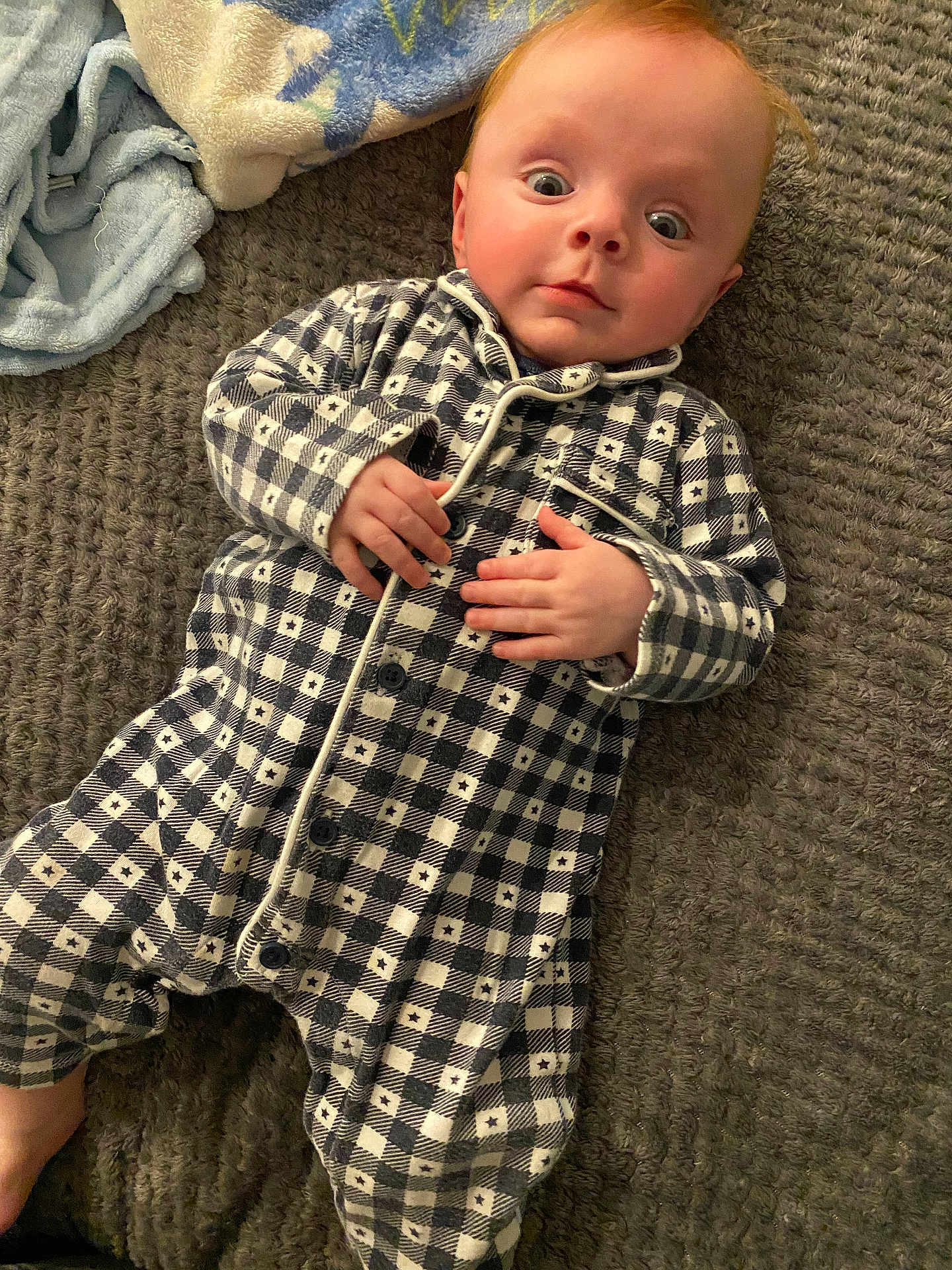 Quintin joined the competition — help win amazing prizes! baby, child, infant, onesie, checkered, blanket, texture, lying_down, hand, face, wide_eyes, curious, soft_lighting, indoor, cozy, cute, person, portrait, sleepwear, young