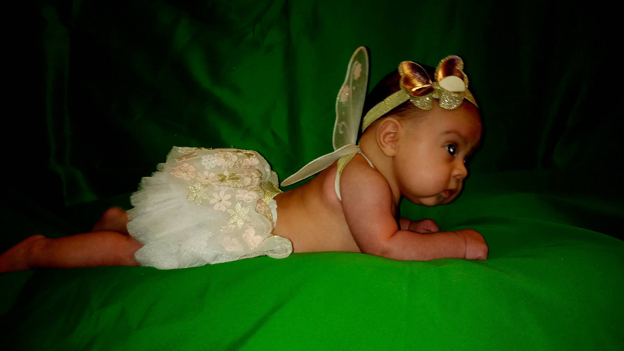 Ciara is registered to the contest to win money with this photo: baby, baby_toddler_clothing, costume_hat, dress, eye, finger, flash_photography, fun, grass, happy, hat, headband, headgear, headpiece, headwear, human_body, jewellery, person, petal, skin