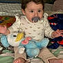 Maialen joined the competition — help win amazing prizes! baby, child, pacifier, plush_toy, duck, bed, blanket, bow, clothing, sitting, indoors, cute, soft_toy, foot, pajamas, person, face, childhood, comfort, cozy