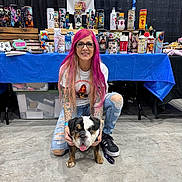 China joined the competition — help win amazing prizes! black_shoes, blue_tablecloth, bulldog, casual_clothing, colorful_merchandise, concrete_floor, dog, event, glasses, indoor, kneeling, pet, pink_hair, puppy, ripped_jeans, smiling, table, tattoos, tumbler, woman