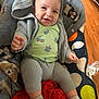 baby, blanket, child, comfort, cozy, cushion, cute, fabric, face, happy, head, indoor, knitwear, pattern, person, seated, smile, socks, water_bottle, wooden_floor