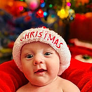 Kolton joined the competition — help win amazing prizes! baby, child, christmas_hat, holiday_lights, red_blanket, face, portrait, indoors, festive, cute, infant, smiling, headwear, seasonal, celebration, warmth, soft_focus, happy, newborn, holiday