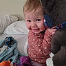 baby, child, infant, smiling, face, portrait, stuffed_animal, gray_toy, bed, bedroom, blanket, pajamas, floral_clothing, toys, baby_bottle, cuddling, indoor, cozy, happy, family_snapshot