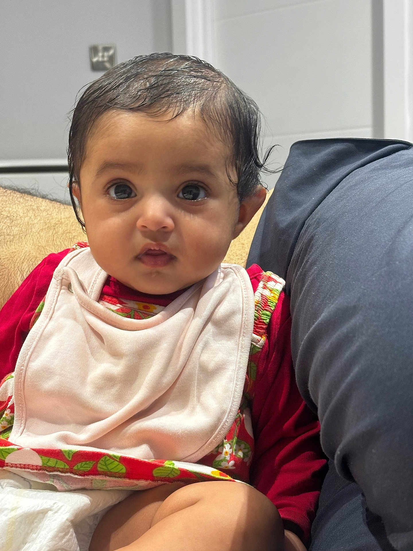 Ojasvita joined the competition — help win amazing prizes! baby, infant, child, face, eyes, clothing, bib, sitting, couch, cushion, indoor, skin, expression, person, cute, young, head, hair, portrait, comfort