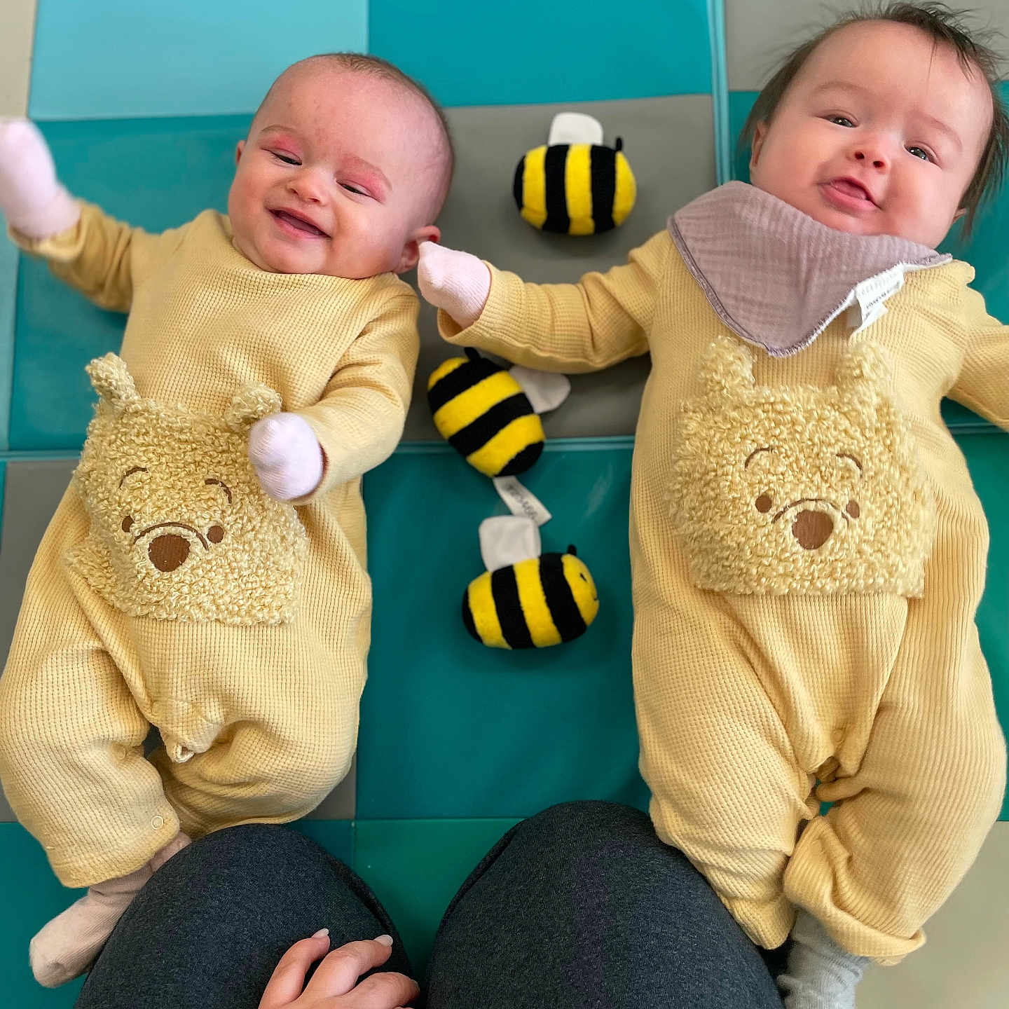 Genesis And Psalm joined the competition — help win amazing prizes! baby, bee_toy, bib, cute, happy, indoor, infant, knees, lying_down, mittens, pajamas, parent_hand, play_mat, playtime, plush_toy, portrait, smile, tiles, twins, yellow_outfit