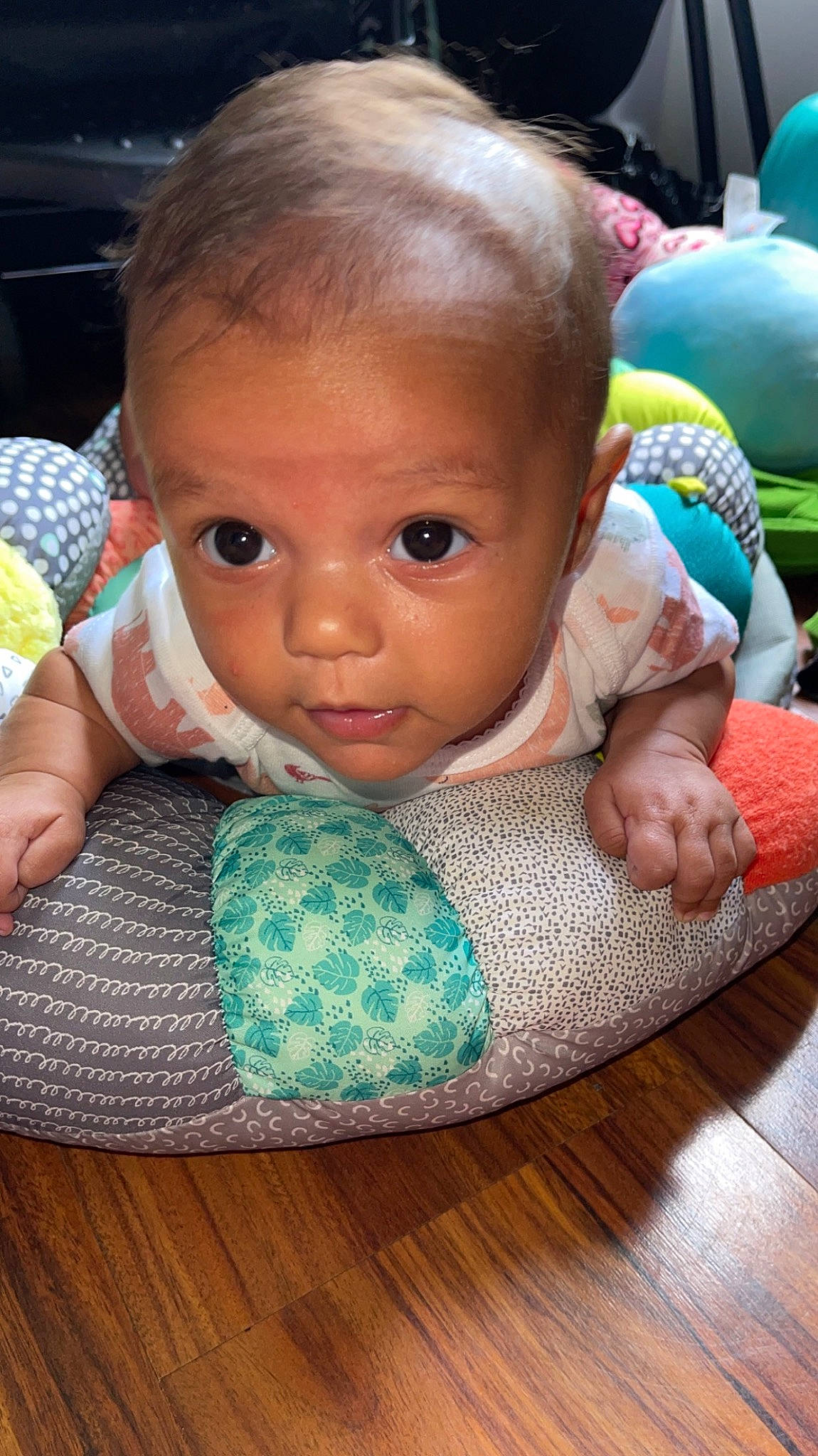 Evelyn is registered to the contest to win money with this photo: baby, baby_products, baby_toddler_clothing, balloon, cheek, child, eyelash, flooring, green, happy, iris, mouth, nail, nose, person, product, sitting, skin, toddler, toy