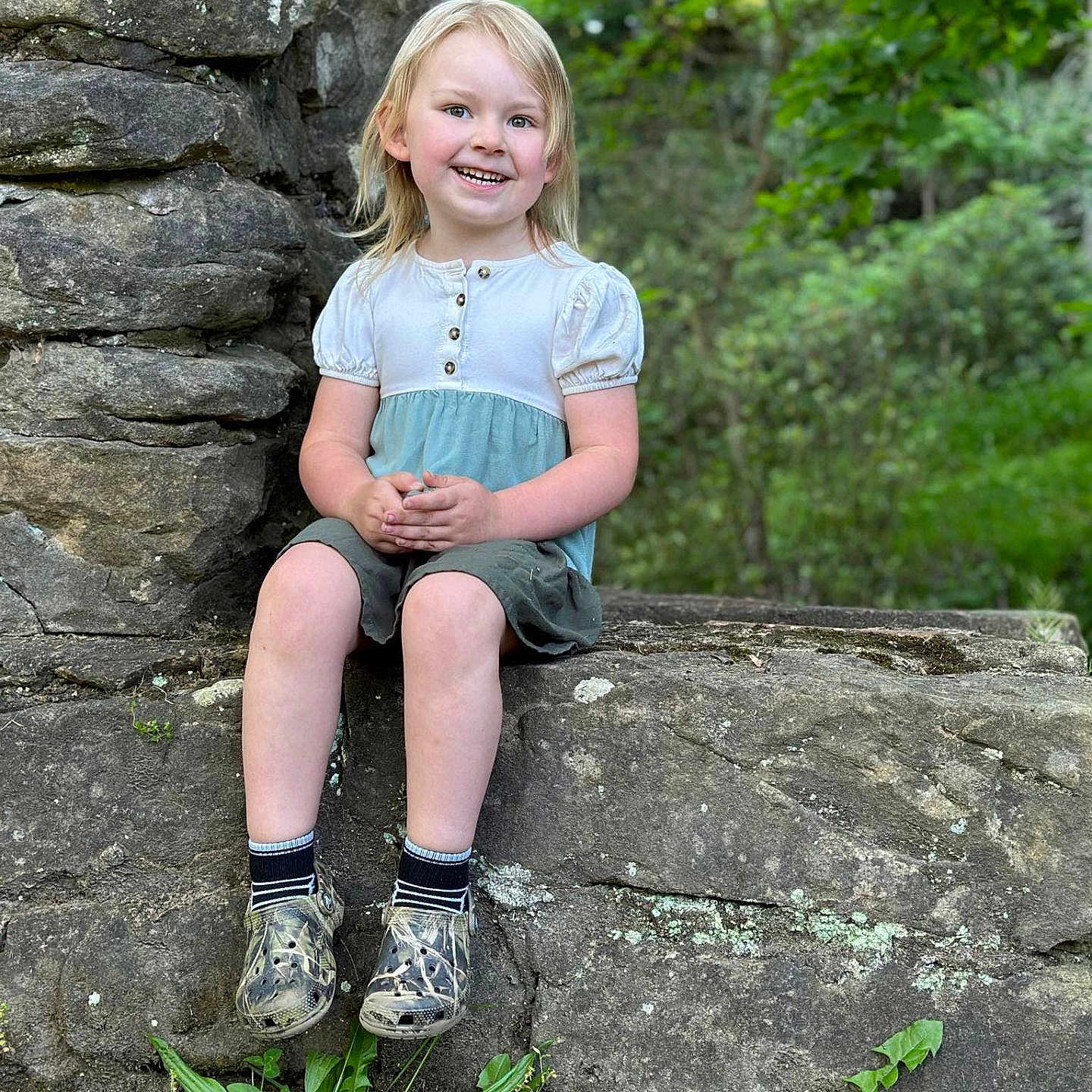 Chloe joined the competition — help win amazing prizes! ball, blonde, child, clothing, face, female, football, footwear, girl, hair, head, person, photography, plant, portrait, rock, shoe, shorts, sitting, vegetation