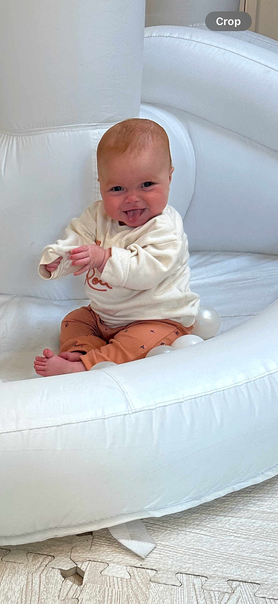 Lotte-Rose joined the competition — help win amazing prizes! baby, infant, child, tongue_out, smiling, white_chair, playful, indoor, cozy_clothes, sitting, cute, happy, light_skin, short_hair, toy_balls, floor_mat, portrait, small_hands, barefoot, warm_lighting