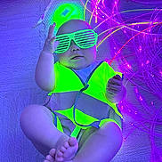 Lotte-Rose is registered to the contest to win money with this photo: baby, child, neon, glasses, safety_vest, floor, feet, hand, purple_lights, fiber_optic, indoor, cute, glowing, accessory, infant, playful, colorful, portrait, fun, fashion
