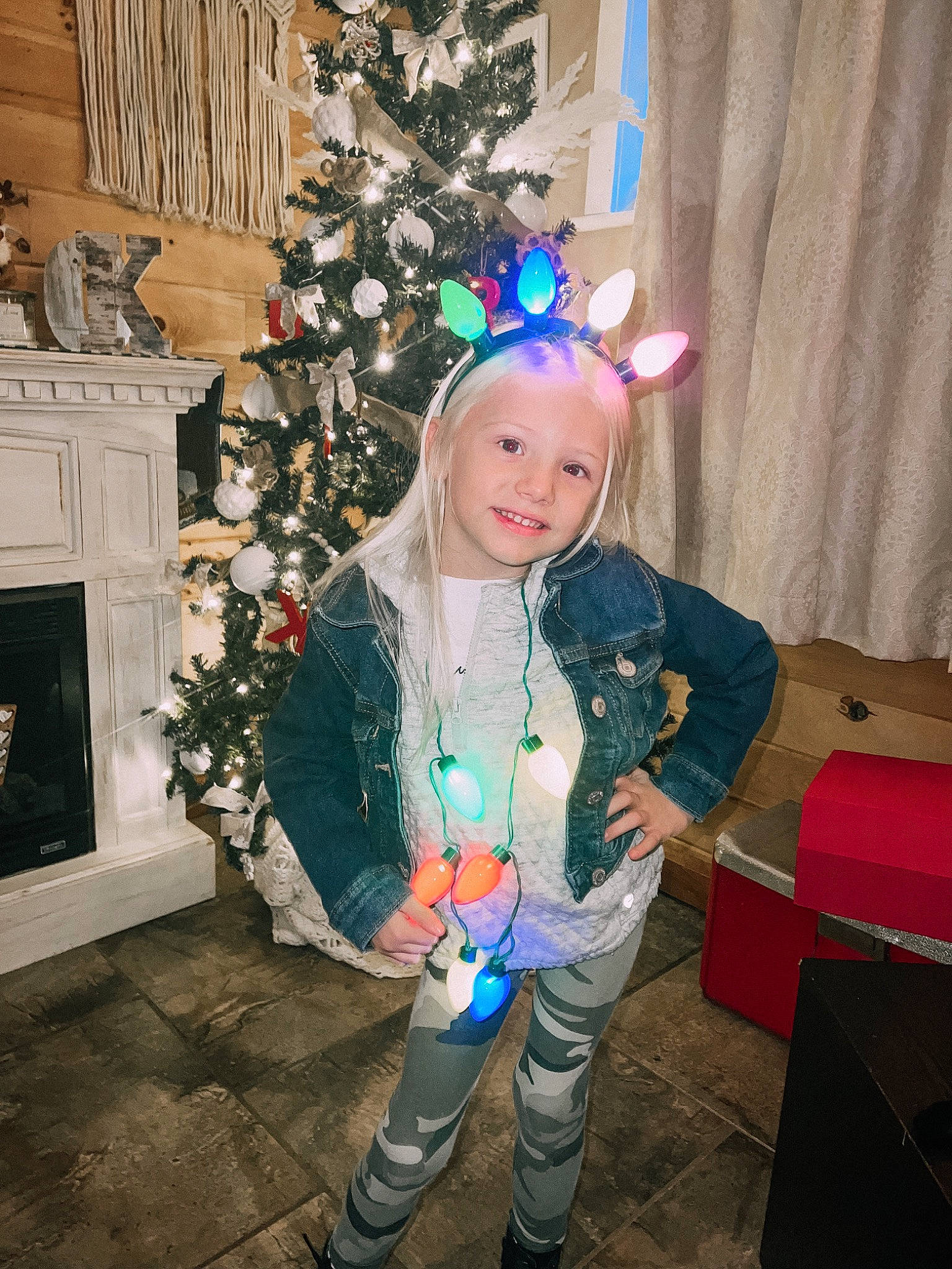 Bailyn Dale is registered to the contest to win money with this photo: boot, box, christmas, christmas_decoration, christmas_eve, christmas_ornament, christmas_tree, costume_hat, event, fun, happy, holiday, holiday_ornament, joy, ornament, person, shipping_box, sitting, smile, toddler