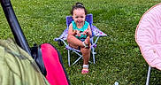 Aylanni is registered to the contest to win money with this photo: backyard, camping_chair, child, curly_hair, folding_chair, garden, grass, meadow, nature, outdoors, pink_chair, playful, portrait, sandals, sitting, smiling, summer, toddler, trees, water_bottle