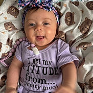 Keonna Marie joined the competition — help win amazing prizes! baby, child, smiling, headband, blanket, teddy_bear, purple_shirt, clothing, cute, happy, indoors, infant, person, face, portrait, sitting, accessory, pacifier_clip, patterned_clothing, cozy