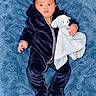 baby, child, infant, portrait, lying_down, blue_blanket, navy_outfit, hooded_outfit, stuffed_animal, elephant_toy, comforter, wide_eyes, face, hands, indoor, close_up, textile, patterned_background, cute, photography