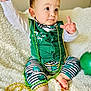 Merrick joined the competition — help win amazing prizes! baby, infant, child, face, portrait, beads, green_clothing, bow_tie, shamrock, striped_pants, blanket, sitting, toy, celebration, st_patricks_day, festive, cute, indoor, close_up, curious_expression