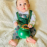 Merrick joined the competition — help win amazing prizes! baby, infant, child, sitting, bow_tie, green_outfit, beads, pot_of_gold_toy, rainbow_toy, striped_pants, barefeet, blanket, soft_texture, portrait, closeup, curious_expression, big_eyes, holiday_theme, st_patricks, indoor