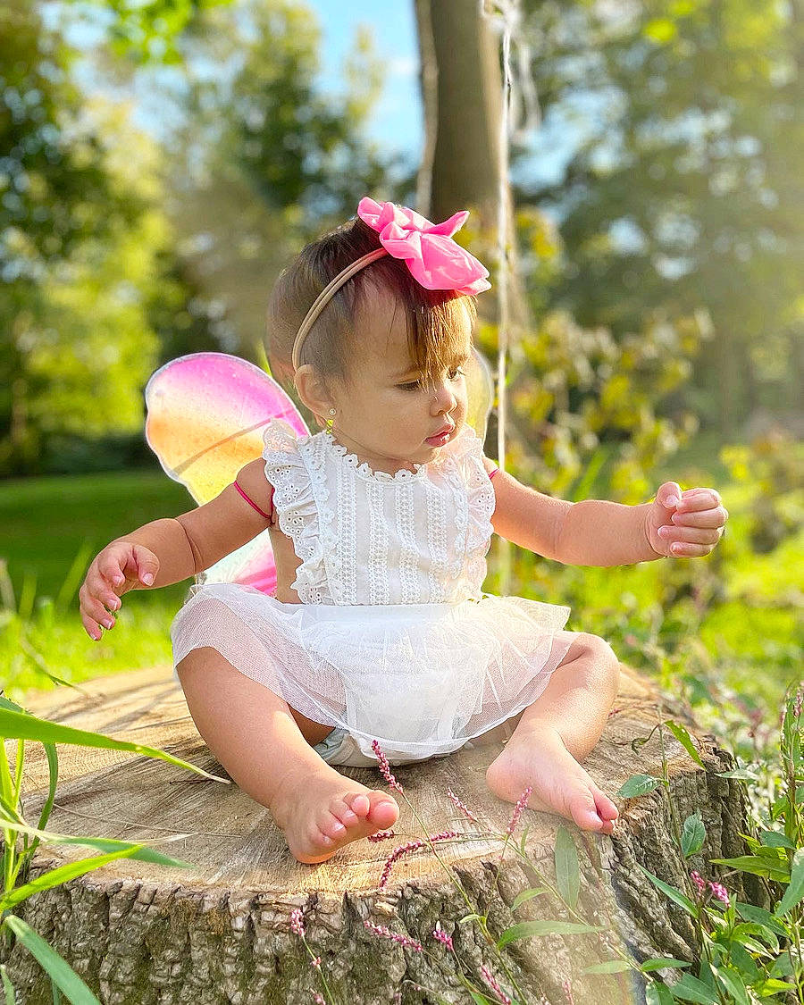 Bella is registered to the contest to win money with this photo: baby_toddler_clothing, beauty, child, dress, flash_photography, fun, grass, grass_family, happy, leisure, magenta, meadow, people_in_nature, person, pink, plant, summer, sunlight, thigh, toddler