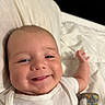 Woodrow is registered to the contest to win money with this photo: baby, smiling, face, tongue, bed, blanket, white_clothing, infant, happy, skin, head, cheeks, hand, lying_down, comfort, cute, portrait, indoors, child, person
