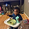 Ever joined the competition — help win amazing prizes! toddler, child, high_chair, food, sippy_cup, indoor, wood_floor, slippers, toy, plate, blue_clothing, person, meal, snack, furniture, home, face, floor, baby, cute