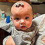 Noelle joined the competition — help win amazing prizes! baby, infant, child, face, eyes, hand, clothing, bow, kitchen, cabinet, counter, person, sleeve, holding, expression, skin, indoor, portrait, cute, young