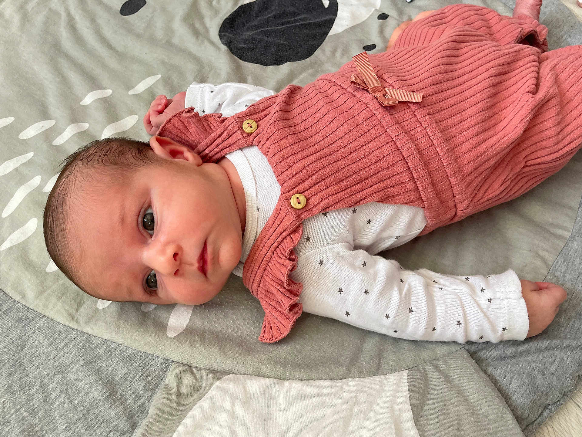 Soline a rejoint le concours — aidez-le/la à gagner de superbes lots ! baby, infant, child, face, eyes, clothing, blanket, pattern, pink_outfit, white_onesie, stars, cute, soft, lying_down, newborn, portrait, indoors, young, skin, head