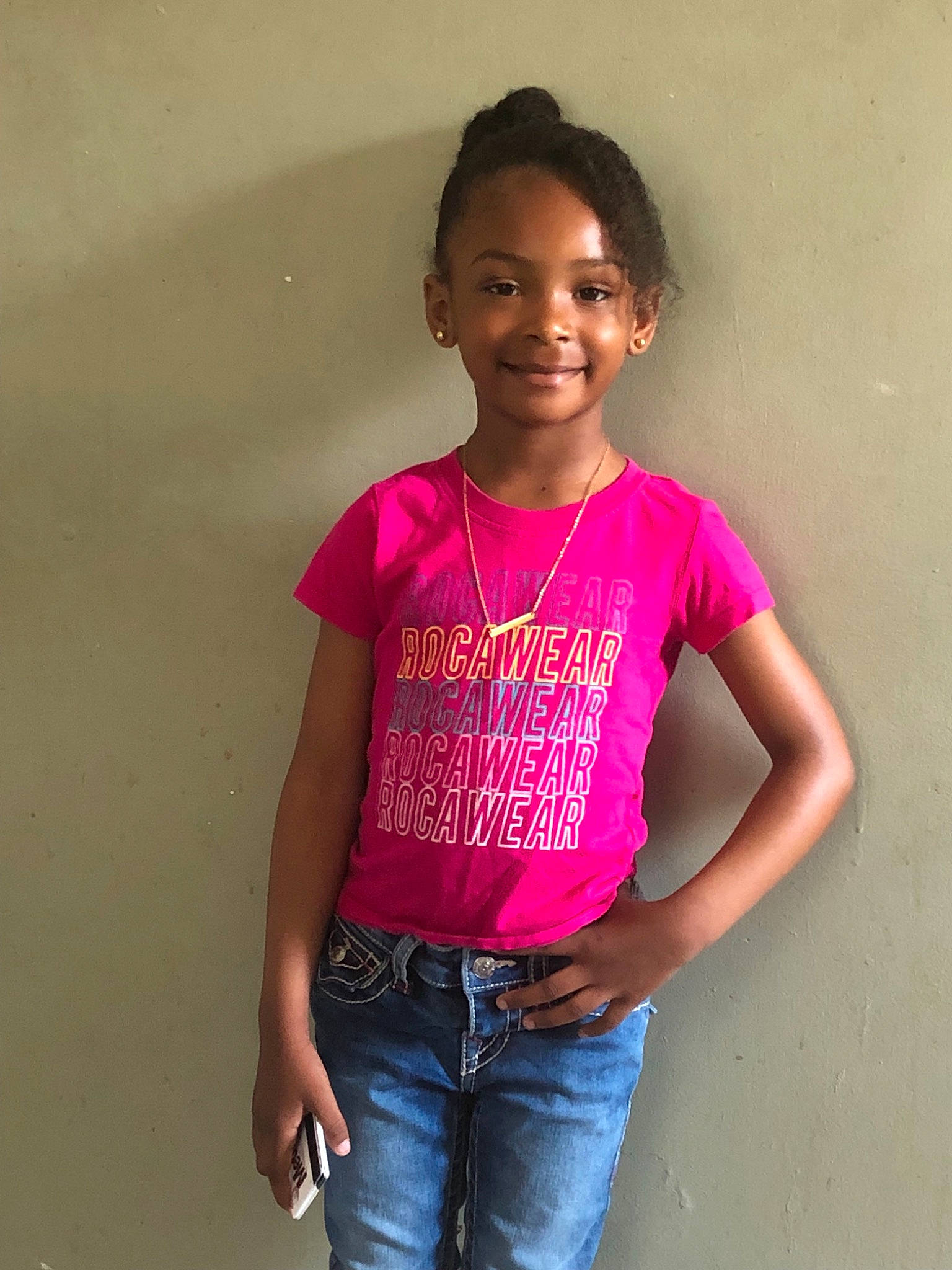 Jolie is registered to the contest to win money with this photo: child, child_model, jeans, joy, magenta, neck, person, pink, shoulder, sleeve, smile, standing, t_shirt, top