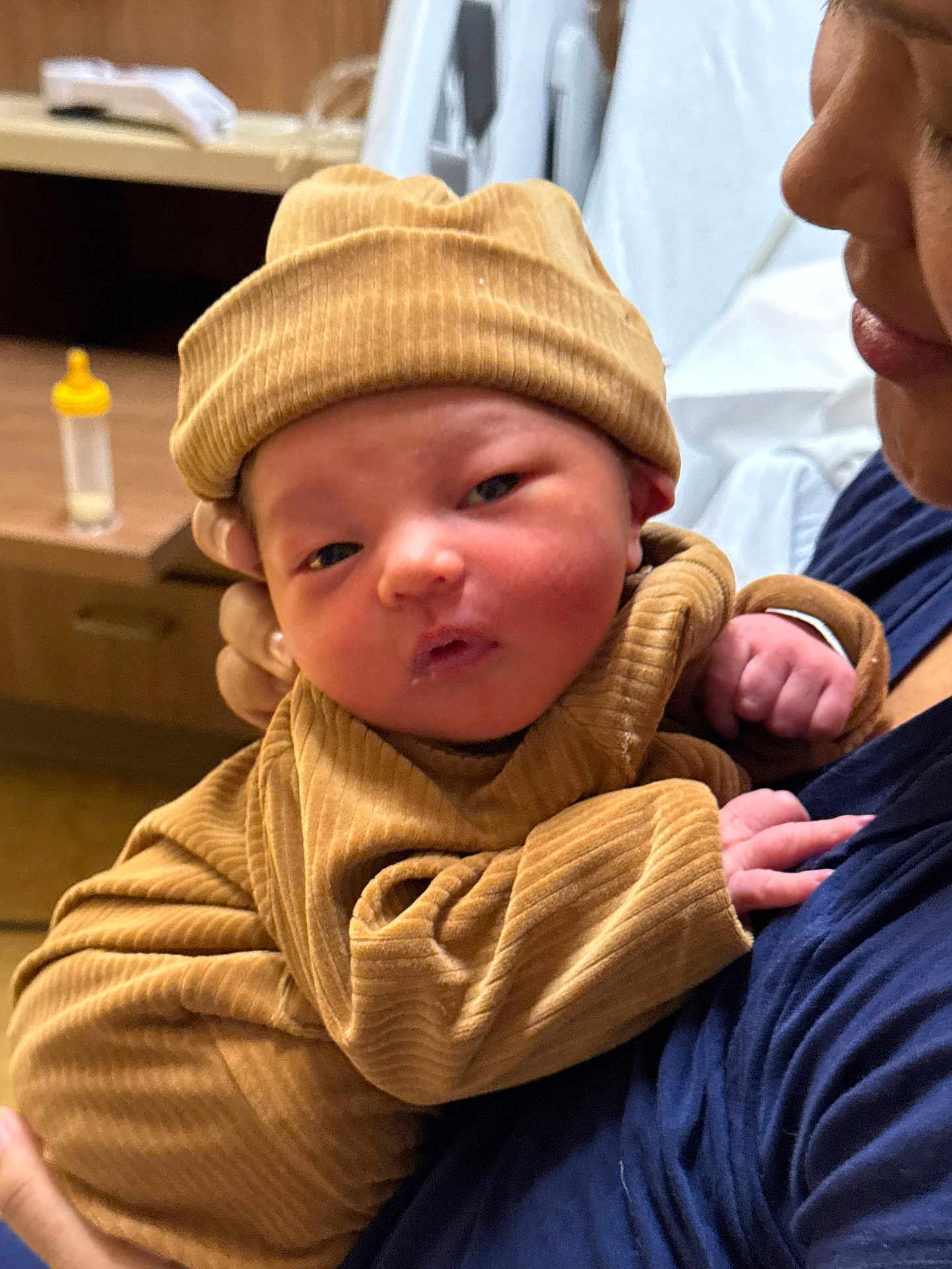 Shella joined the competition — help win amazing prizes! arm, baby, beanie, bedside_table, blanket, bottle, cheeks, closeup, cuddle, face, hat, holding, hospital_room, infant, newborn, onesie, parent, portrait, ribbed_clothing, skin